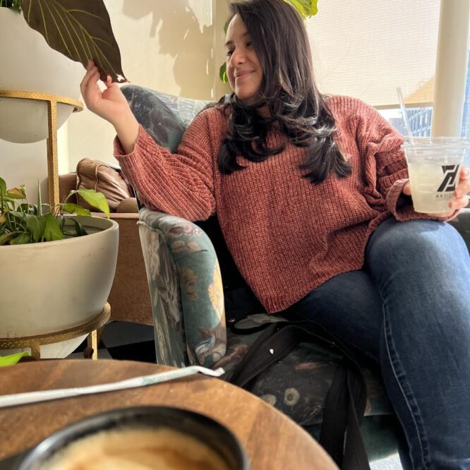 woman looking at plant in coffee shop