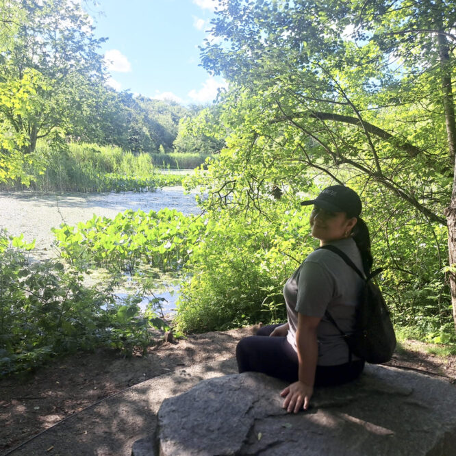 woman sitting on a rock in a park