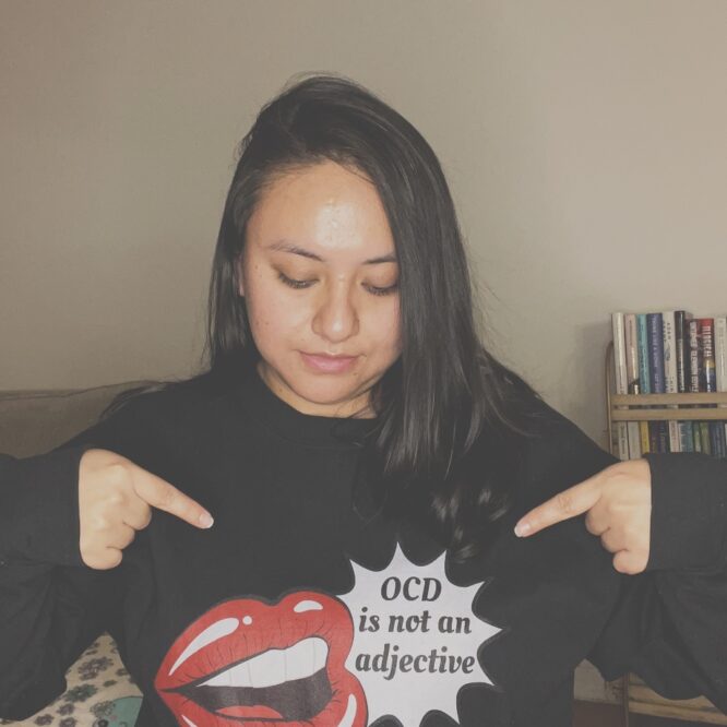 A woman wearing a sweater that reads OCD is not an adjective