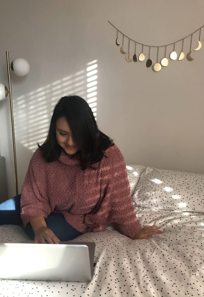 A photo of me sitting on my bed and working on my laptop.